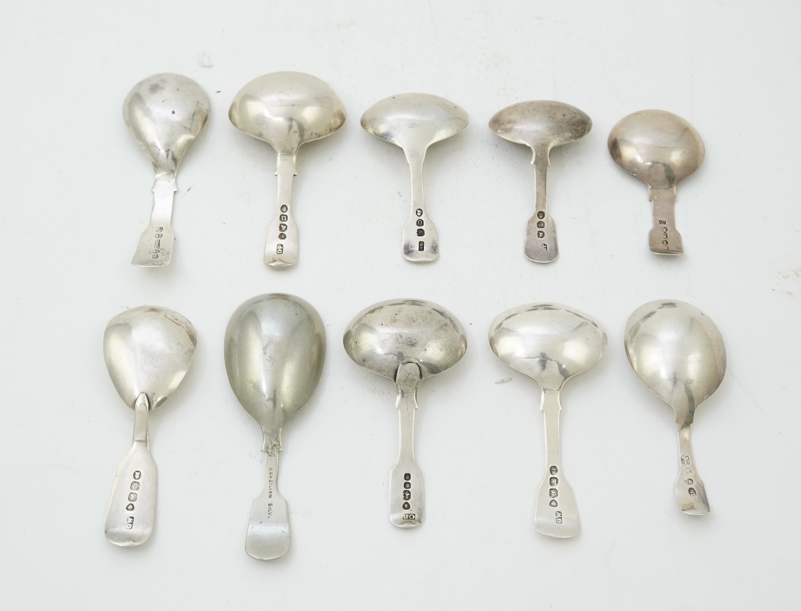 A collection of ten assorted mainly 19th century silver and white metal fiddle pattern caddy spoons
